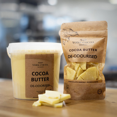 Cocoa butter container and packaging on a wooden surface with a blurred background