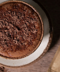 Close up of a milk hot chocolate topped with chocolate flakes